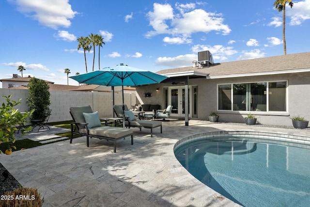 back of property with french doors, stucco siding, outdoor lounge area, a patio area, and fence