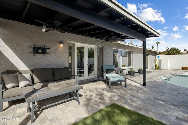 view of patio / terrace featuring a fenced in pool, french doors, a ceiling fan, fence, and an outdoor living space