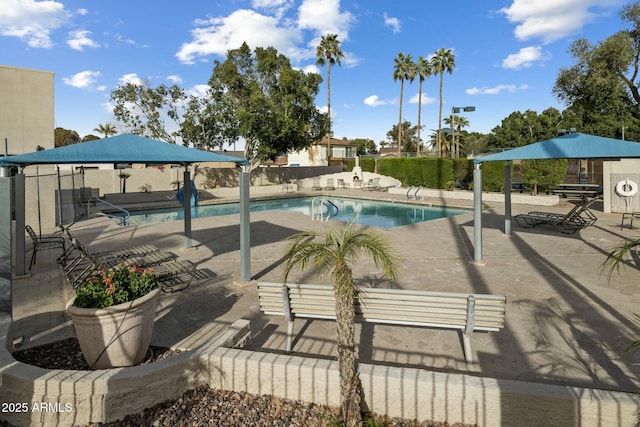 community pool with a patio area and fence