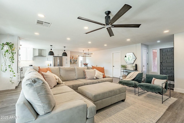 living area featuring recessed lighting, visible vents, light wood-style flooring, ceiling fan, and baseboards