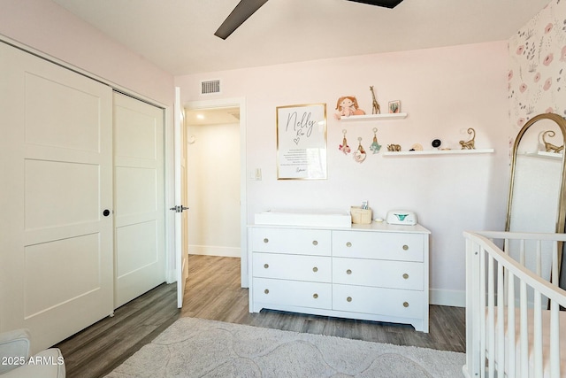 bedroom featuring wood finished floors, visible vents, and baseboards