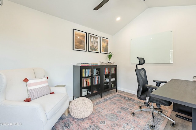 office space with a ceiling fan, vaulted ceiling, baseboards, and wood finished floors