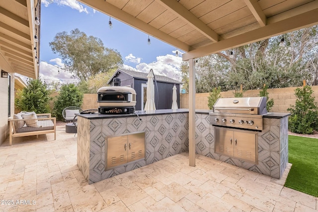 view of patio with an outbuilding, area for grilling, a grill, a fenced backyard, and an outdoor living space