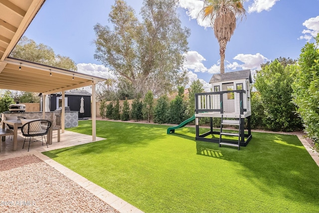 view of yard featuring a patio area, a playground, and a fenced backyard