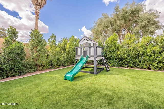 community play area featuring a fenced backyard and a yard