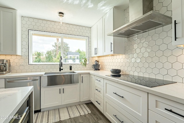 kitchen with decorative backsplash, a sink, wall chimney range hood, dishwasher, and black electric cooktop