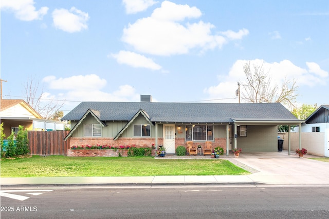 single story home with a front yard, concrete driveway, brick siding, and fence