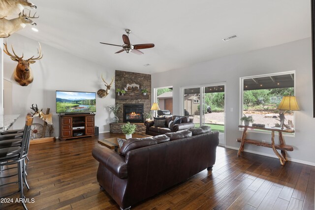 living room with ceiling fan, a fireplace, dark hardwood / wood-style flooring, and brick wall