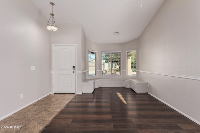 foyer entrance featuring lofted ceiling and dark hardwood / wood-style floors