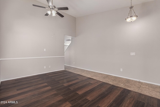 unfurnished room featuring vaulted ceiling, ceiling fan, and dark hardwood / wood-style flooring