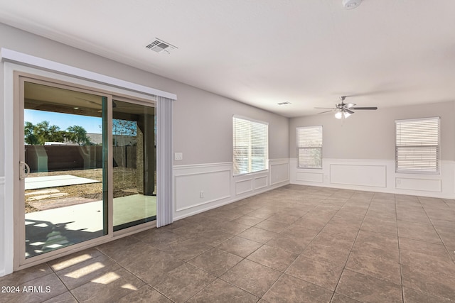 tiled spare room with ceiling fan