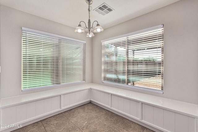 unfurnished dining area with a notable chandelier and tile patterned flooring