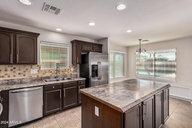 kitchen with tasteful backsplash, a healthy amount of sunlight, stainless steel appliances, and sink