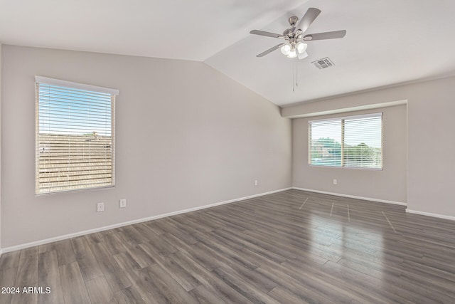 empty room featuring lofted ceiling, dark wood-type flooring, and ceiling fan