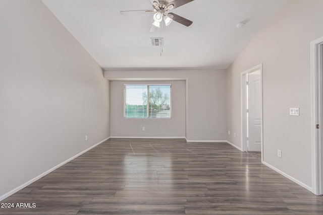 empty room with ceiling fan, vaulted ceiling, and dark hardwood / wood-style flooring