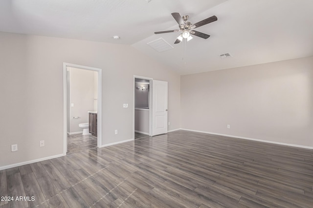 unfurnished bedroom featuring lofted ceiling, dark hardwood / wood-style floors, ensuite bath, and ceiling fan