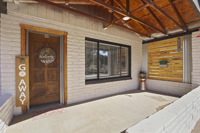 doorway to property featuring brick siding