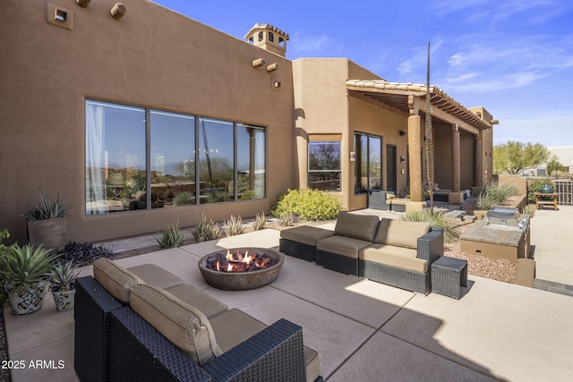 view of patio / terrace with an outdoor living space with a fire pit