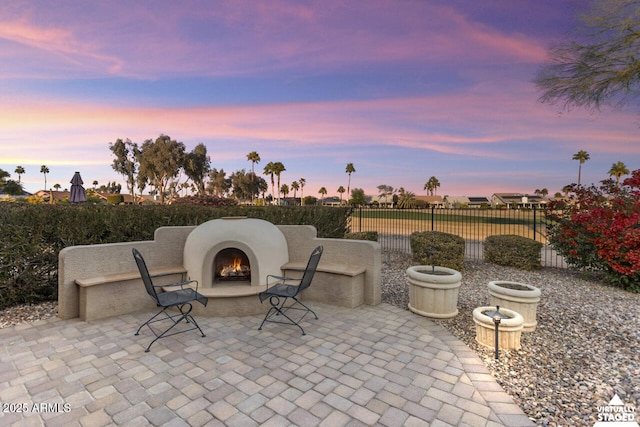 patio terrace at dusk with an outdoor fireplace