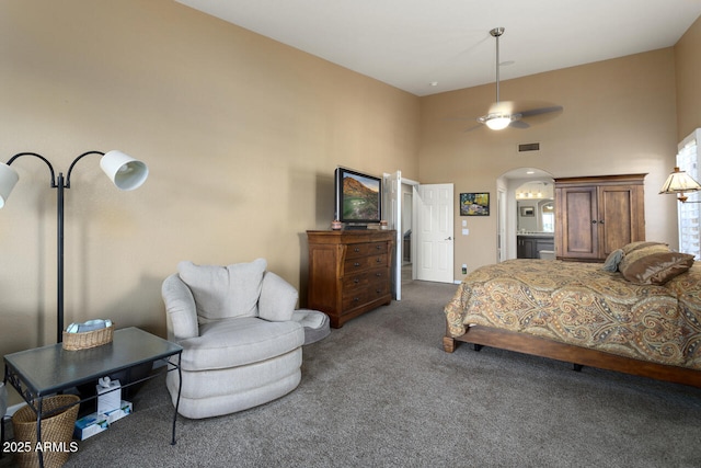 bedroom featuring a towering ceiling and dark colored carpet