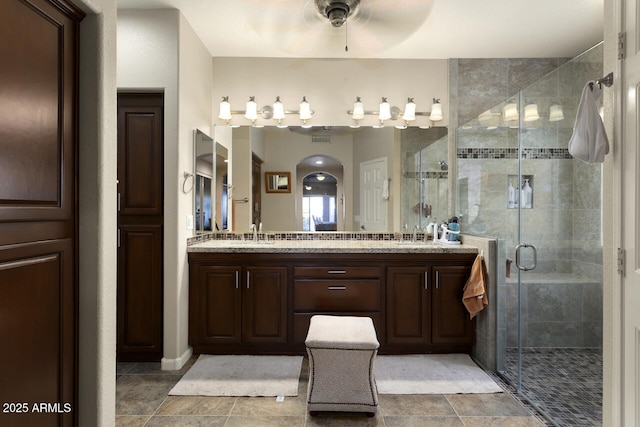 bathroom with vanity, ceiling fan, and walk in shower