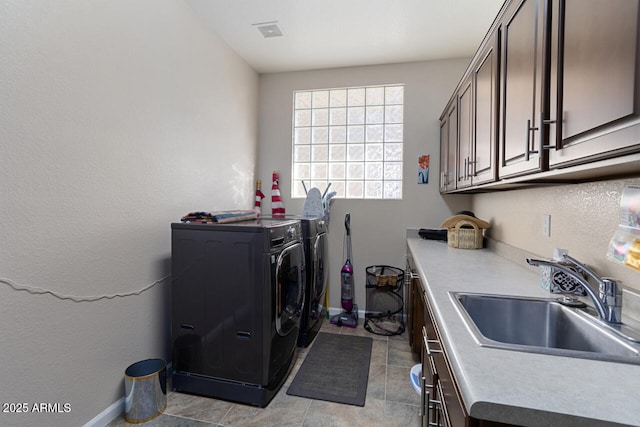 washroom featuring washer and dryer, sink, and cabinets