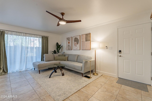 living area featuring ornamental molding, ceiling fan, baseboards, and light tile patterned floors