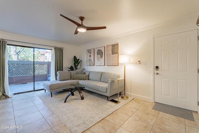 living room with ceiling fan, crown molding, baseboards, and light tile patterned floors