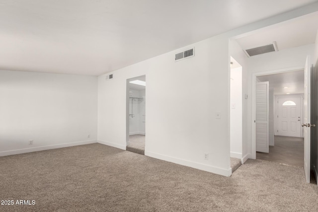 carpeted spare room with visible vents and baseboards