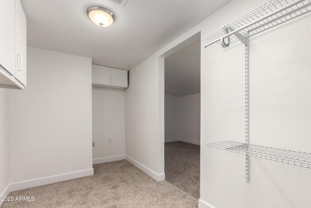 spacious closet featuring light carpet