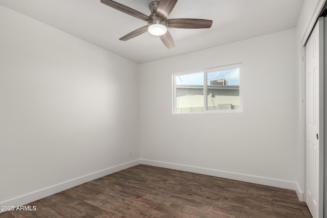 empty room with dark wood-style floors, baseboards, and a ceiling fan