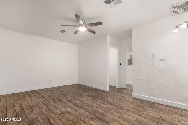 unfurnished room featuring visible vents, baseboards, and wood finished floors