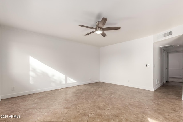 spare room featuring baseboards, visible vents, ceiling fan, and crown molding