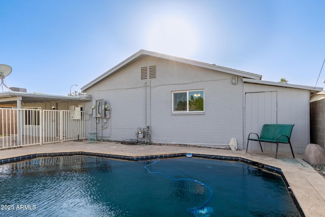 outdoor pool featuring fence and a patio