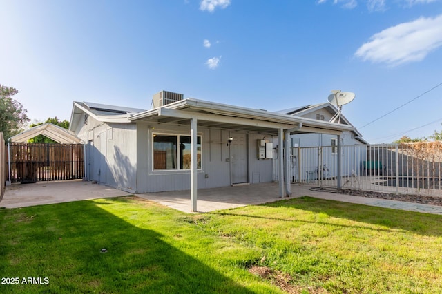 rear view of house with central air condition unit, a yard, a fenced backyard, and a patio