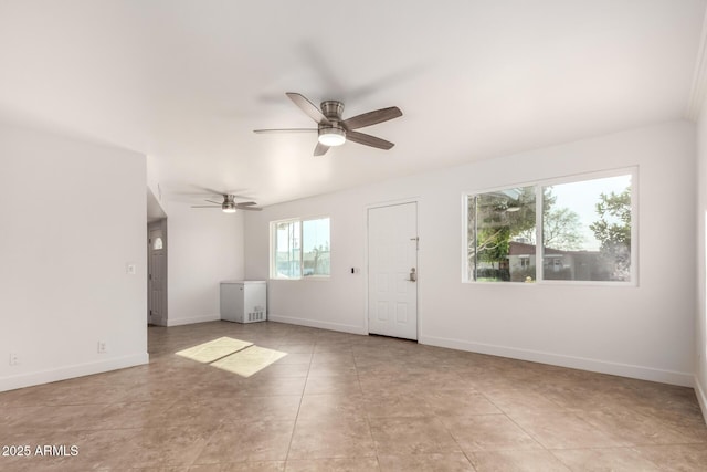 spare room with ceiling fan, tile patterned flooring, and baseboards