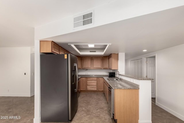 kitchen featuring visible vents, a raised ceiling, appliances with stainless steel finishes, a peninsula, and a sink