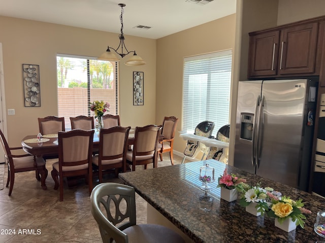 dining space featuring tile patterned flooring and a chandelier