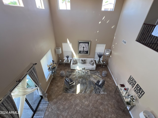 unfurnished living room with a towering ceiling and plenty of natural light