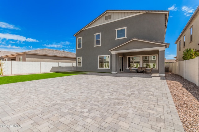 back of house featuring an outdoor living space and a patio