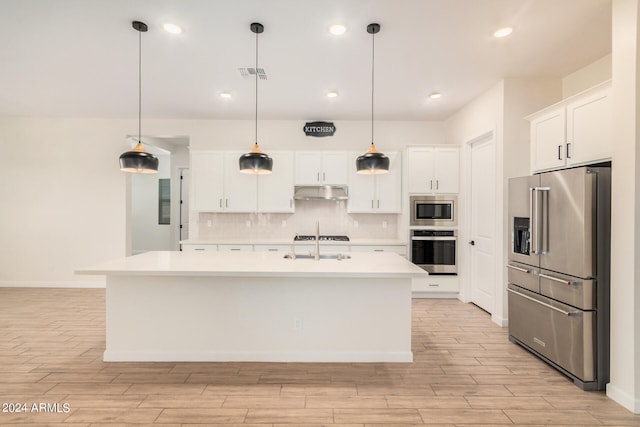 kitchen with a kitchen island with sink, backsplash, stainless steel appliances, and white cabinets