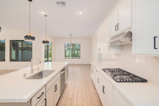 kitchen with an island with sink, light hardwood / wood-style flooring, sink, and white cabinetry