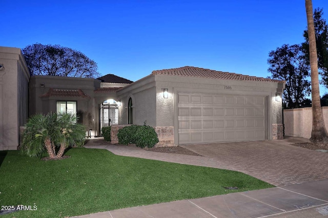 7596 N Via De La Siesta, Scottsdale, AZ 85258 - mediterranean / spanish-style home with stucco siding, a garage, a tile roof, driveway, and a front lawn