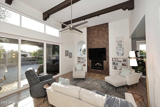 7596 N Via De La Siesta, Scottsdale, AZ 85258 - living room featuring a high ceiling, wood finished floors, a fireplace, arched walkways, and ceiling fan
