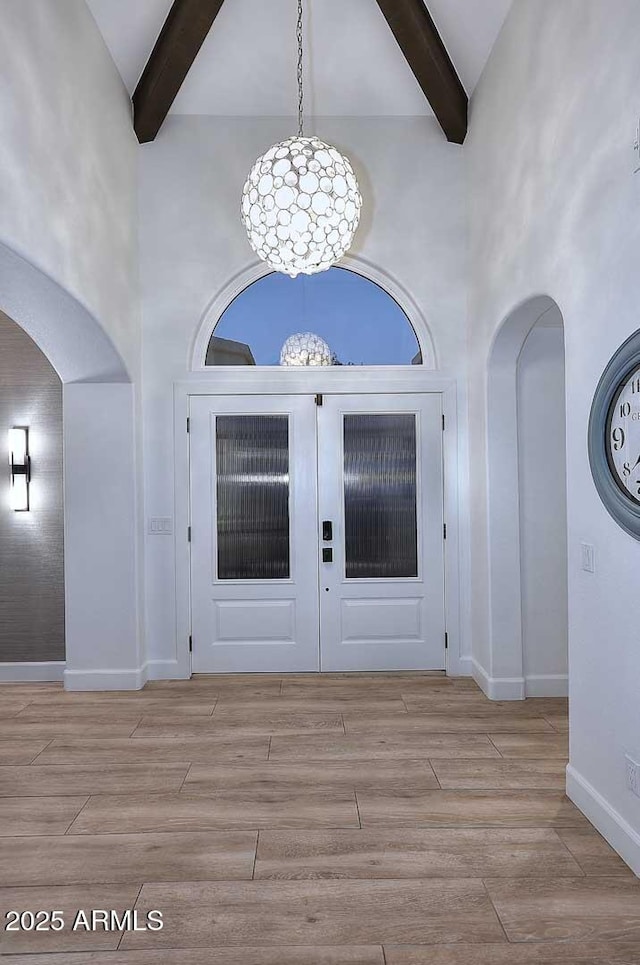 7596 N Via De La Siesta, Scottsdale, AZ 85258 - foyer featuring arched walkways, beam ceiling, high vaulted ceiling, wood finished floors, and baseboards