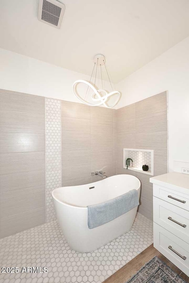 7596 N Via De La Siesta, Scottsdale, AZ 85258 - full bath featuring a freestanding bath, a chandelier, and tile walls