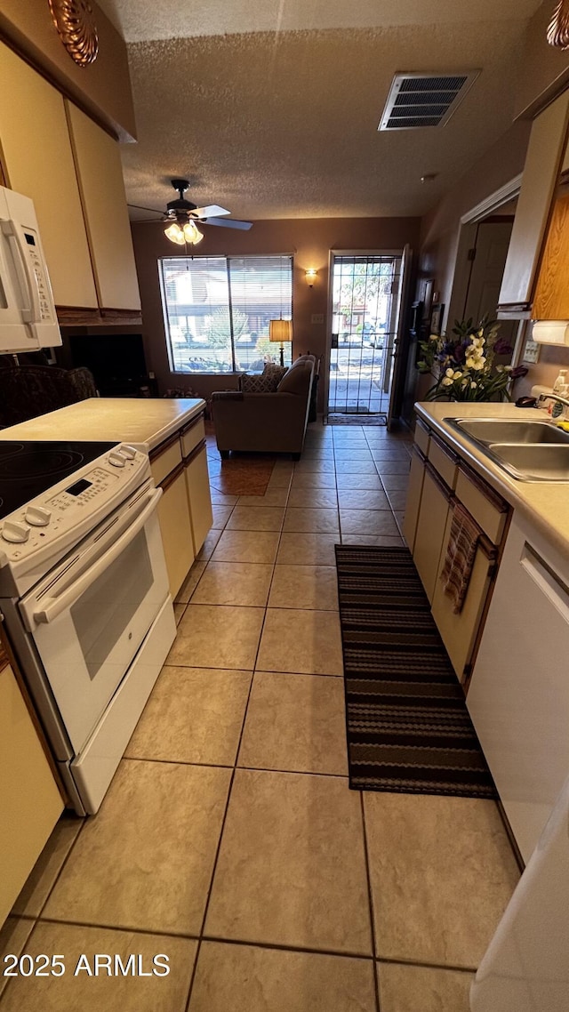 1440 N Idaho Rd Unit 1022, Apache Junction, AZ 85119 - kitchen featuring white appliances, a sink, light tile patterned flooring, healthy amount of natural light, and a textured ceiling