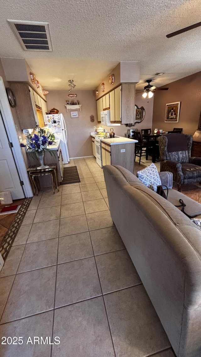 1440 N Idaho Rd Unit 1022, Apache Junction, AZ 85119 - living area featuring light tile patterned floors, a textured ceiling, and ceiling fan
