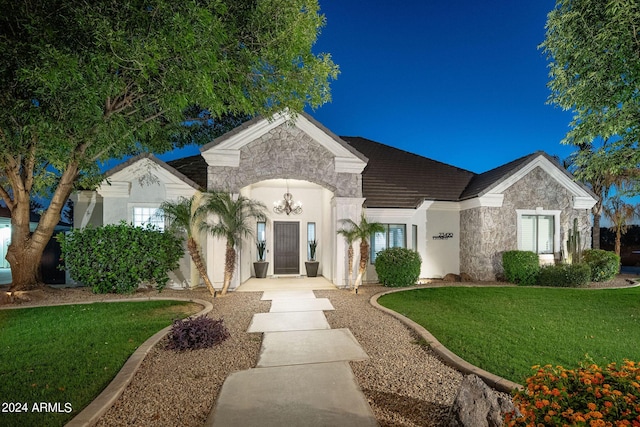 exterior space with stone siding and a front lawn