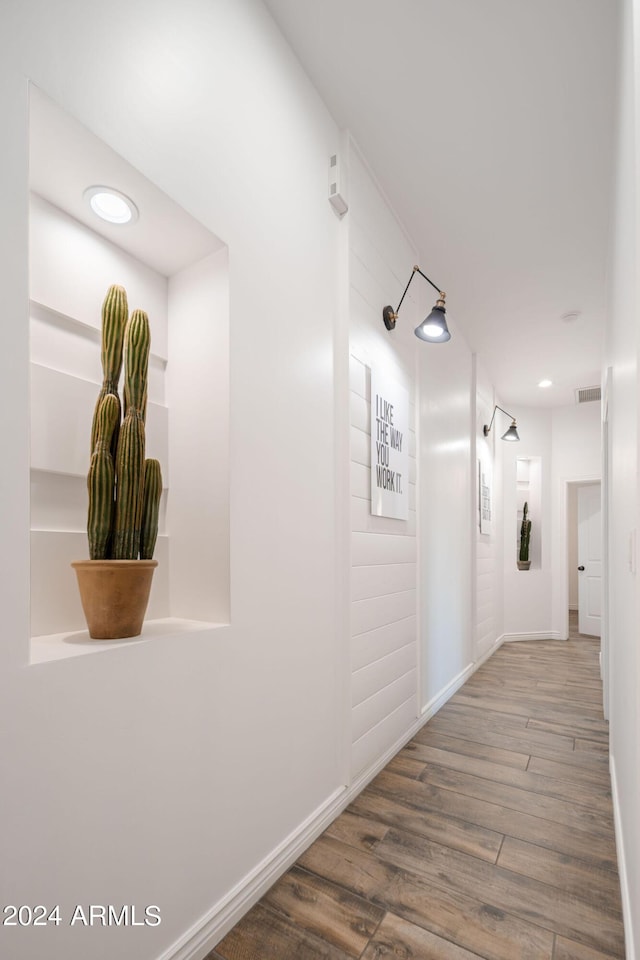 hall with recessed lighting, wood finished floors, visible vents, and baseboards